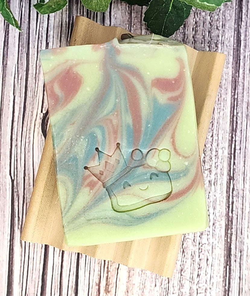 Colorful soap bar with a crown design on a wooden block against a wooden background
