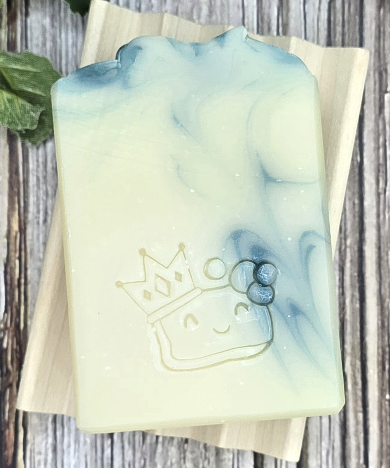 Tea Tree & Rosemary Shampoo bar with a crown design on a wooden surface