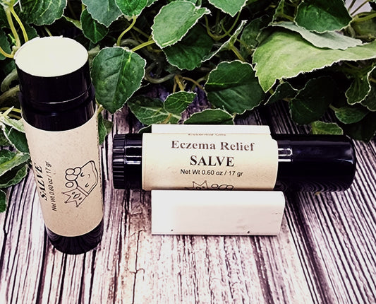 Two bottles of Eczema Relief Salve on a wooden surface with green leaves in the background