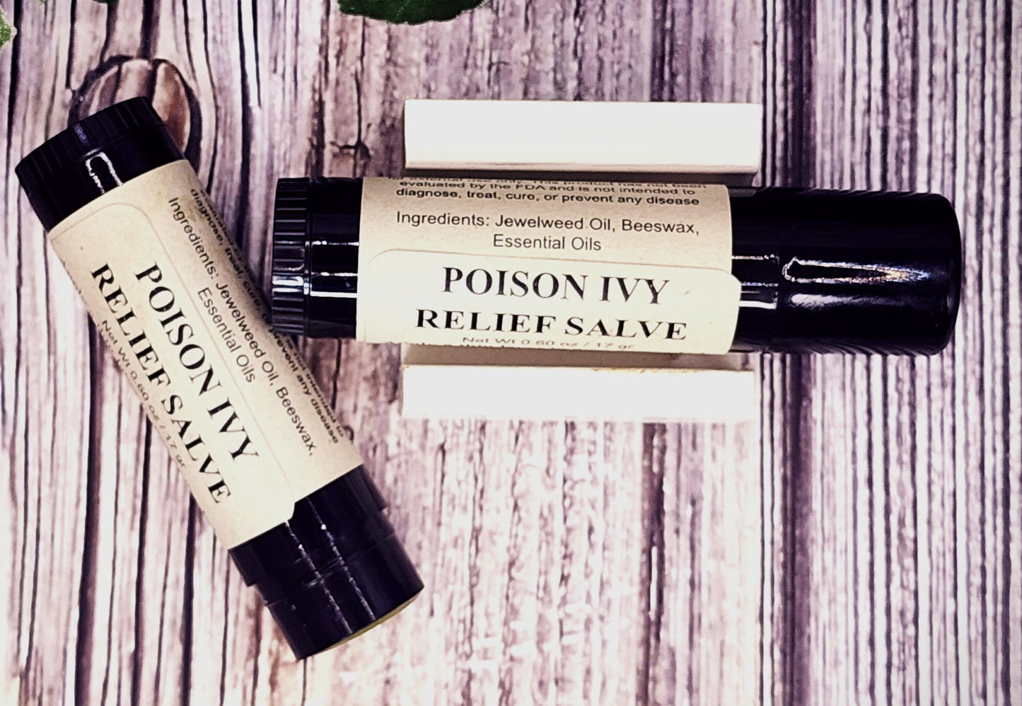 Two bottles of Poison Ivy Relief Salve on a wooden surface