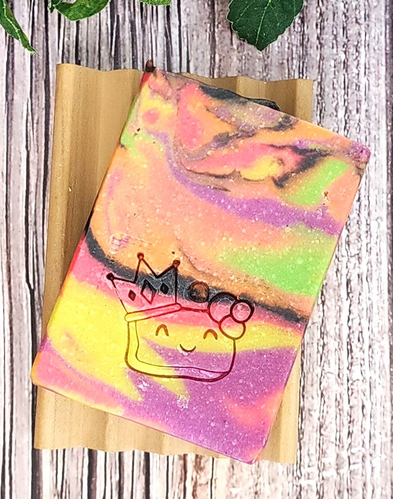 Colorful tie-dye soap with a cartoon character on a wooden surface