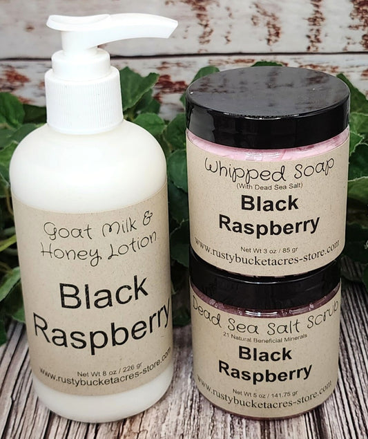 Shows an 8oz bottle of lotion with a 4 oz jar of whipped soap & dead sea salt scrub all scented in Black Raspberry