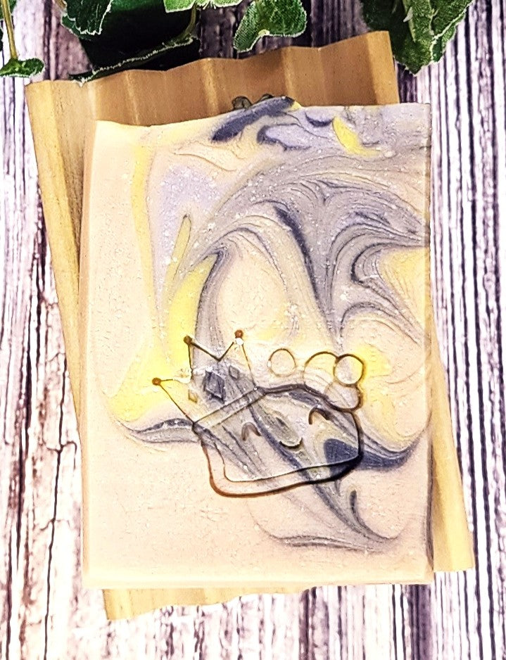 Marbled Black Orchid Soap with a crown design on a wooden surface