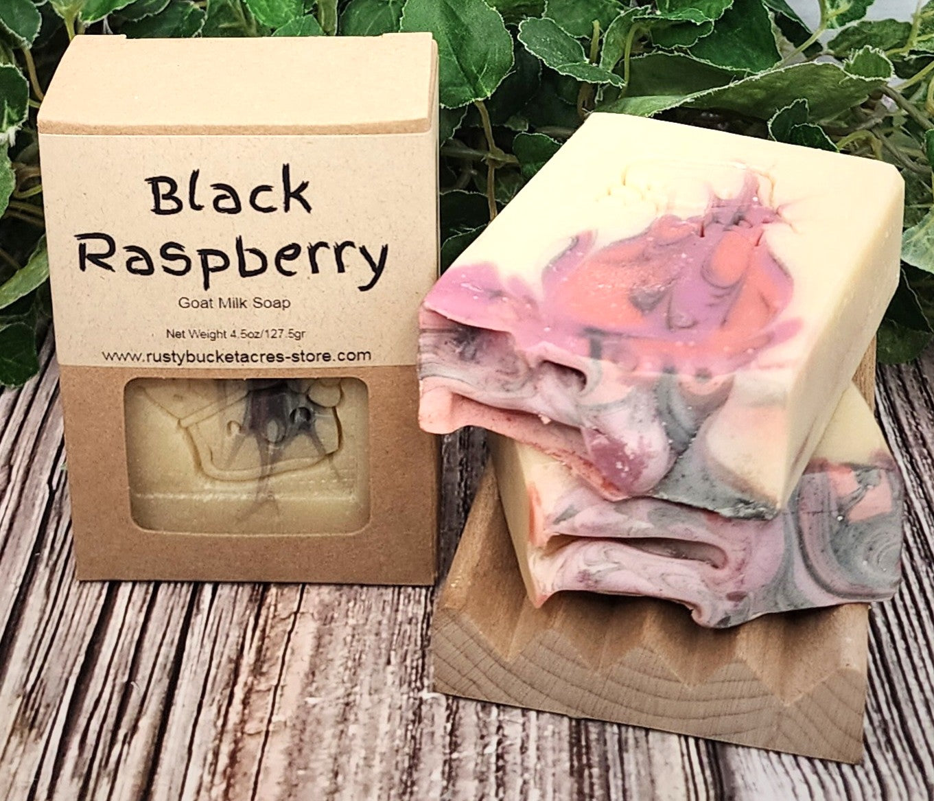 Black Raspberry goat milk soap with packaging on a wooden surface