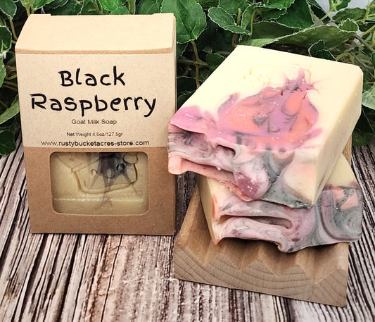 Black Raspberry goat milk soap with packaging on a wooden surface