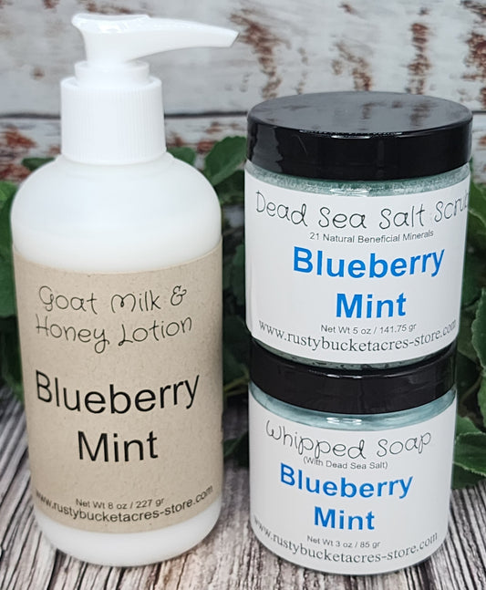 Shows an 8oz bottle of lotion with a 4 oz jar of whipped soap & dead sea salt scrub all scented in Blueberry Mint