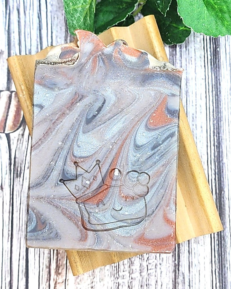 Bourbon Barrel Marbled soap bar on a wooden soap dish