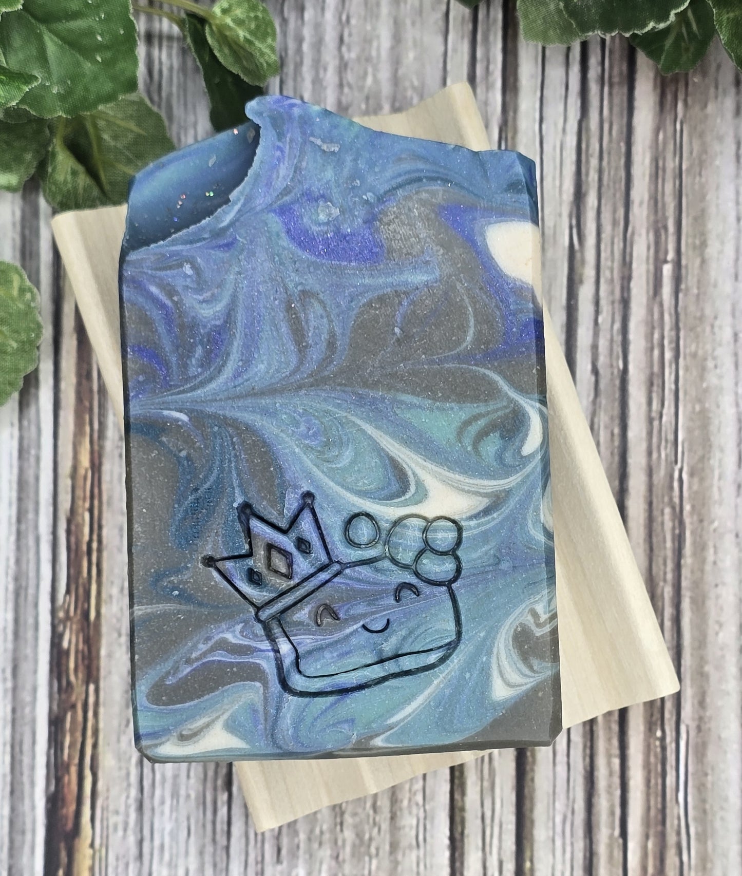 Marbled blue and gray Dark Ice soap on a wooden soap dish