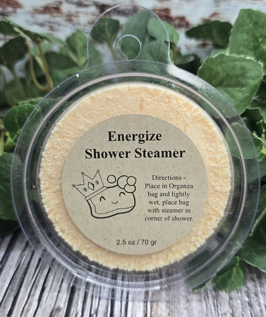 Shower steamer with label on a green leafy background