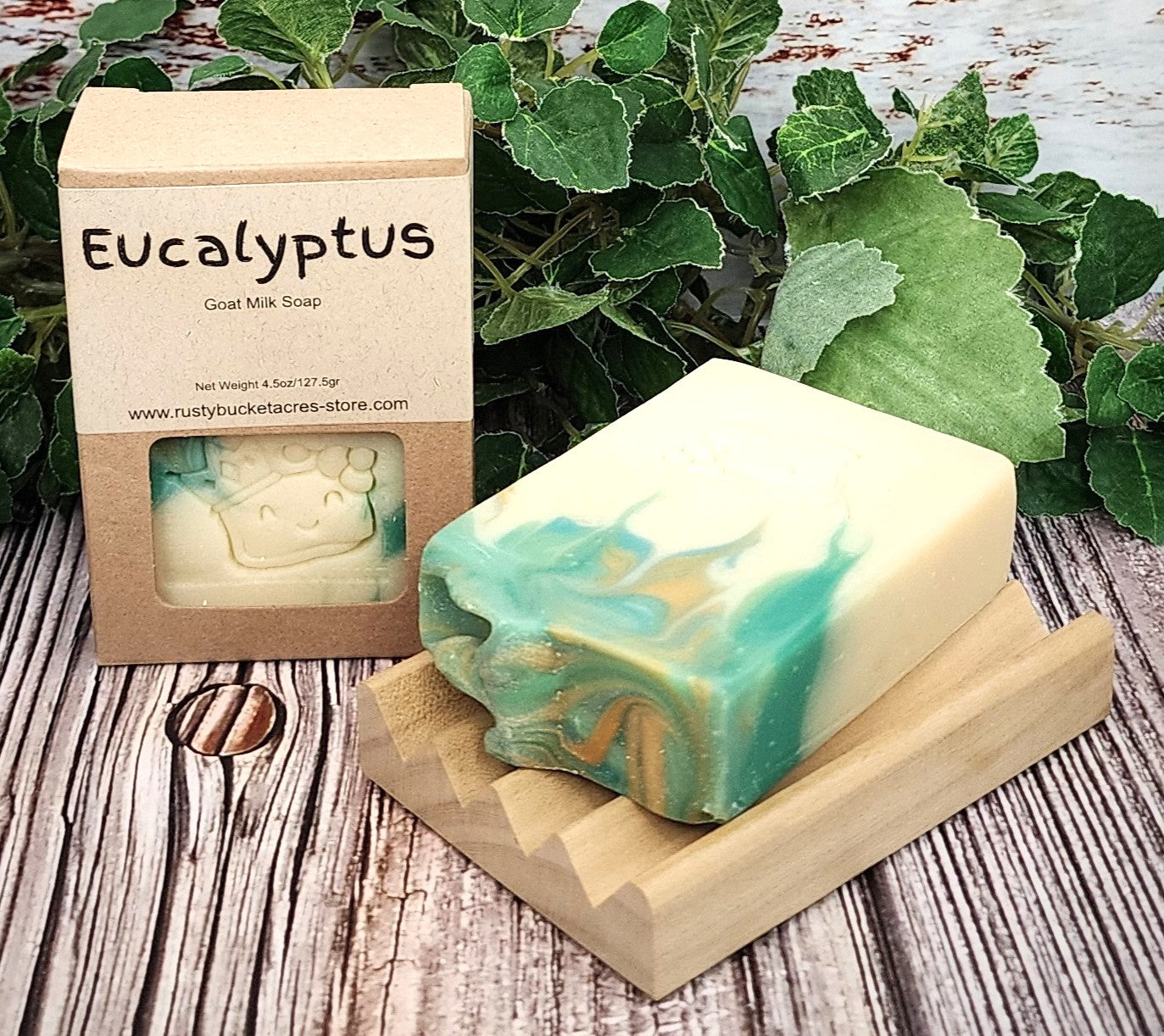 Eucalyptus soap bar with packaging on a wooden surface with green leaves in the background