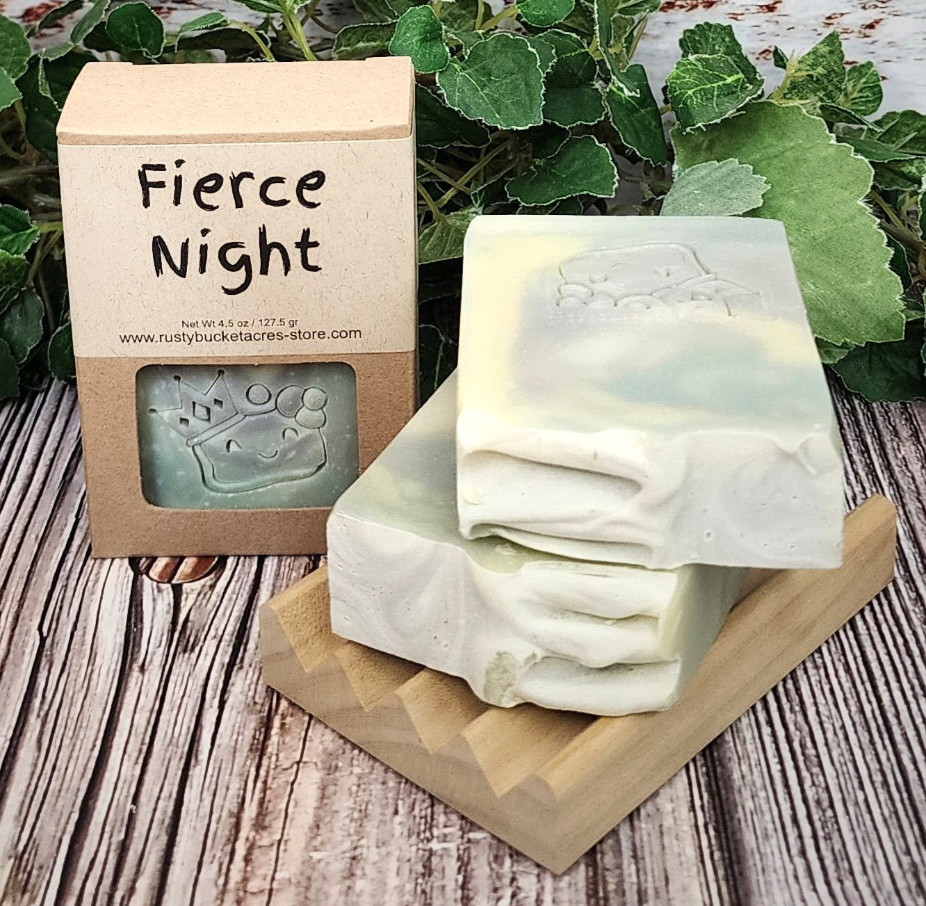 Two bars of soap on a wooden stand with a 'Fierce Night' packaging in the background.