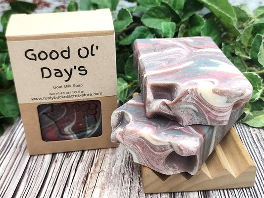 Two marbled soap bars on a wooden block with a 'Good Ol' Day's' packaging in the background.