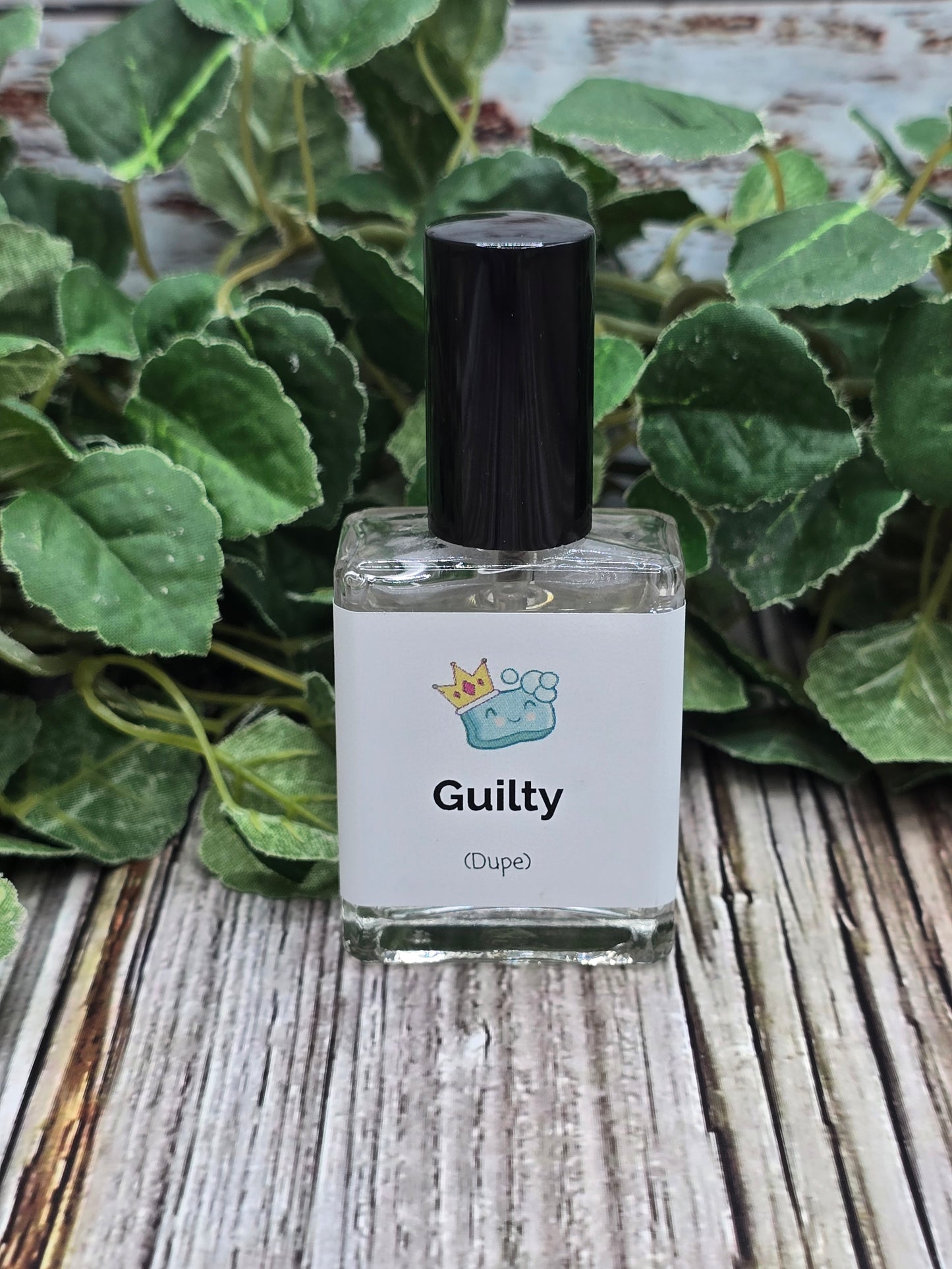 Bottle of perfume labeled 'Guilty' with a plant in the background