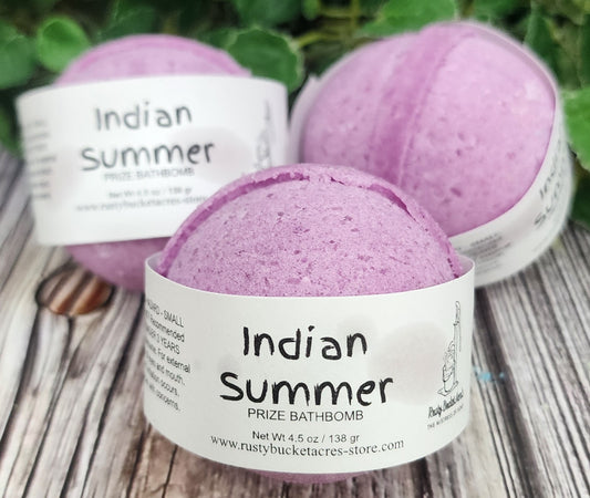 Purple bath bomb with 'Indian Summer' label on a wooden surface