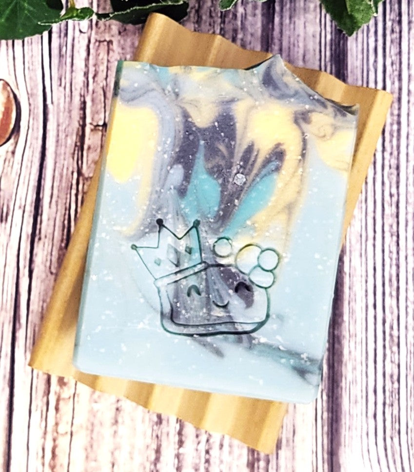 Marble-patterned soap with a crown design on a wooden surface