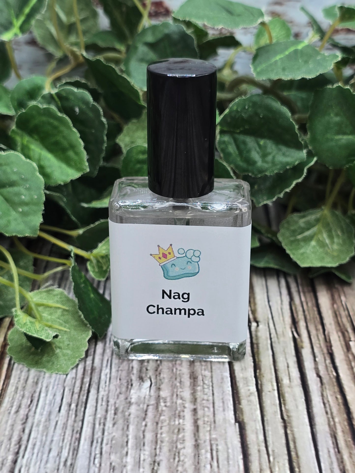 Nag Champa perfume bottle on a wooden surface with green leaves in the background