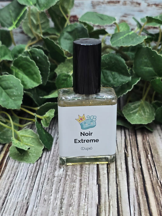 Perfume bottle labeled 'Noir Extreme' on a wooden surface with green leaves in the background
