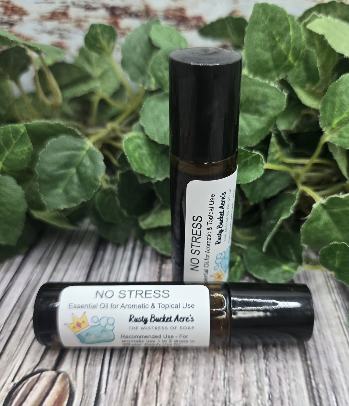 Two bottles of 'No Stress' essential oil with a green leafy background