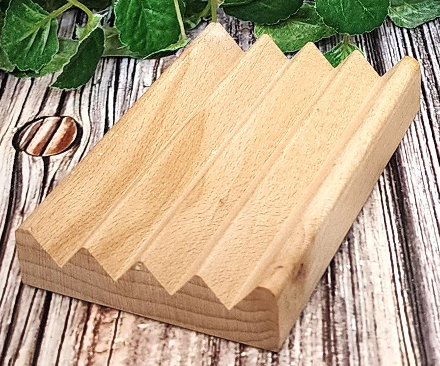 Wooden wedge-shaped blocks on a wooden surface with green leaves in the background