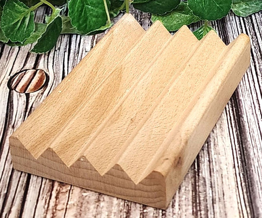 Wooden wedge-shaped blocks on a wooden surface with green leaves in the background