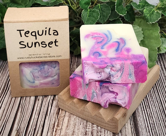 Colorful soap bars with a 'Tequila Sunset' packaging on a wooden surface.