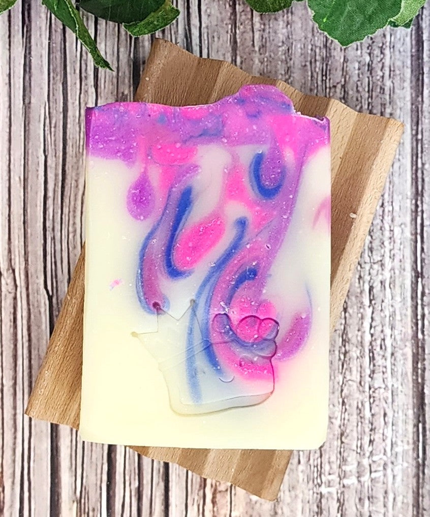 Colorful swirled soap bar on a wooden board with a wooden background