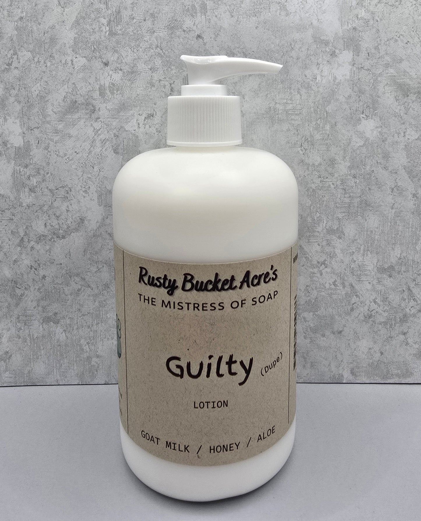 White lotion bottle with pump and 'Rusty Bucket Acres Guilty Dupe' label on a gray background
