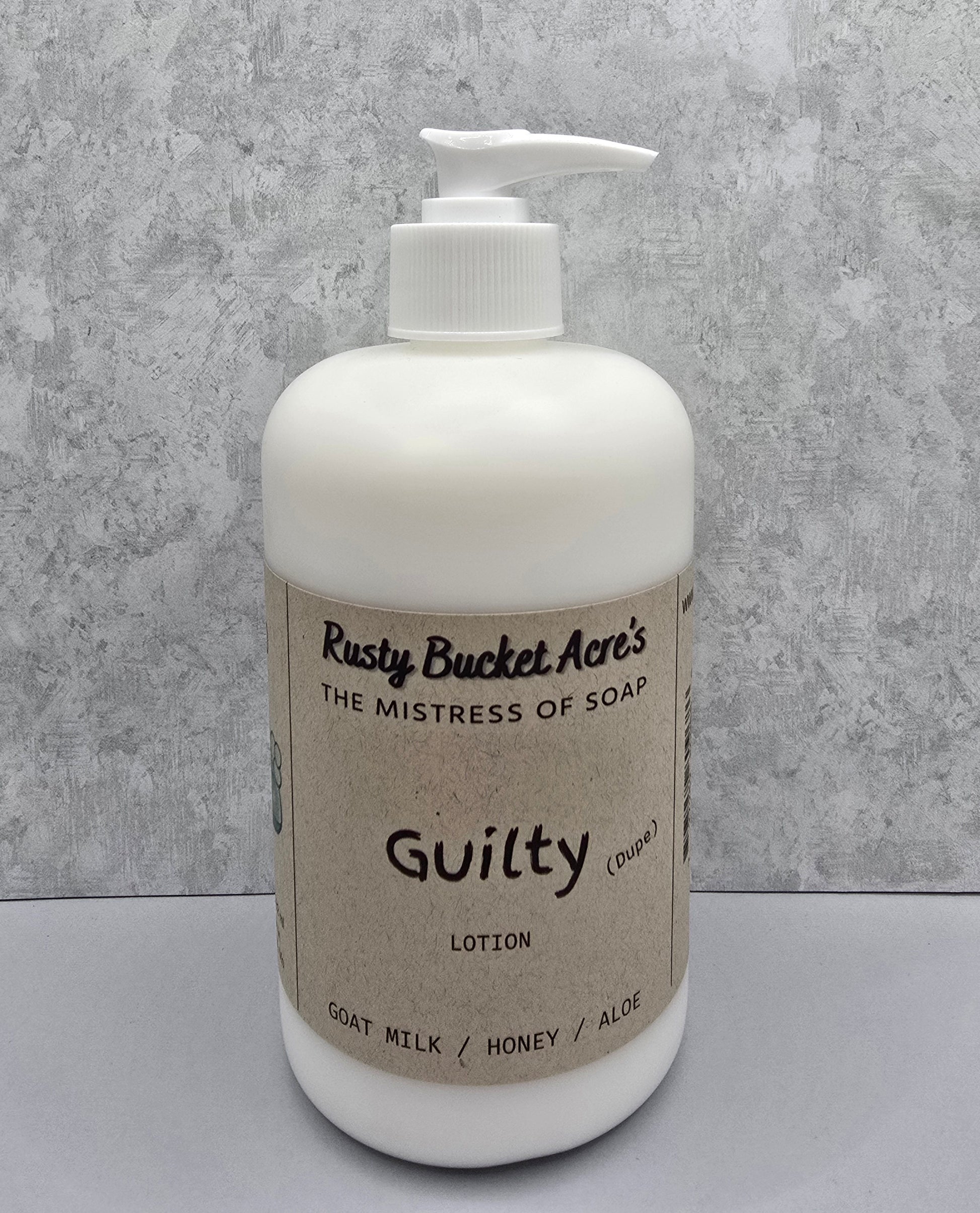 White lotion bottle with pump and 'Rusty Bucket Acres Guilty Dupe' label on a gray background