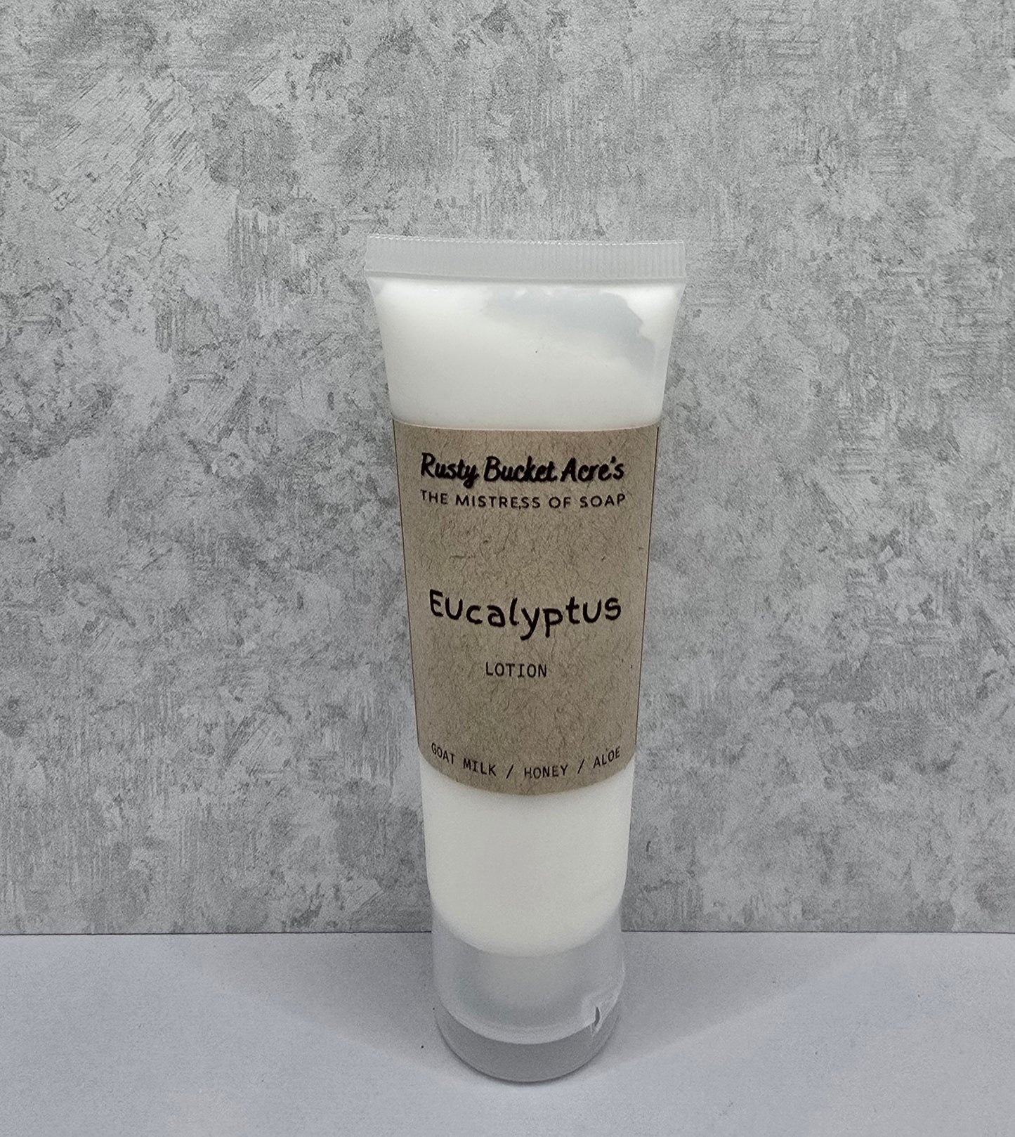 Tube of Eucalyptus lotion with a kraft paper label on a gray background