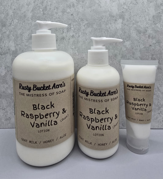 Two bottles and a tube of Rusty Bucket Acres Black Raspberry & Vanilla Dupe lotion on a gray background
