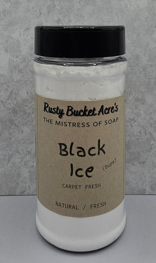 A clear plastic jar of Rusty Bucket Acre's 'Black Ice' carpet fresh soap, filled with white lather and topped with a black lid, set against a gray textured background.