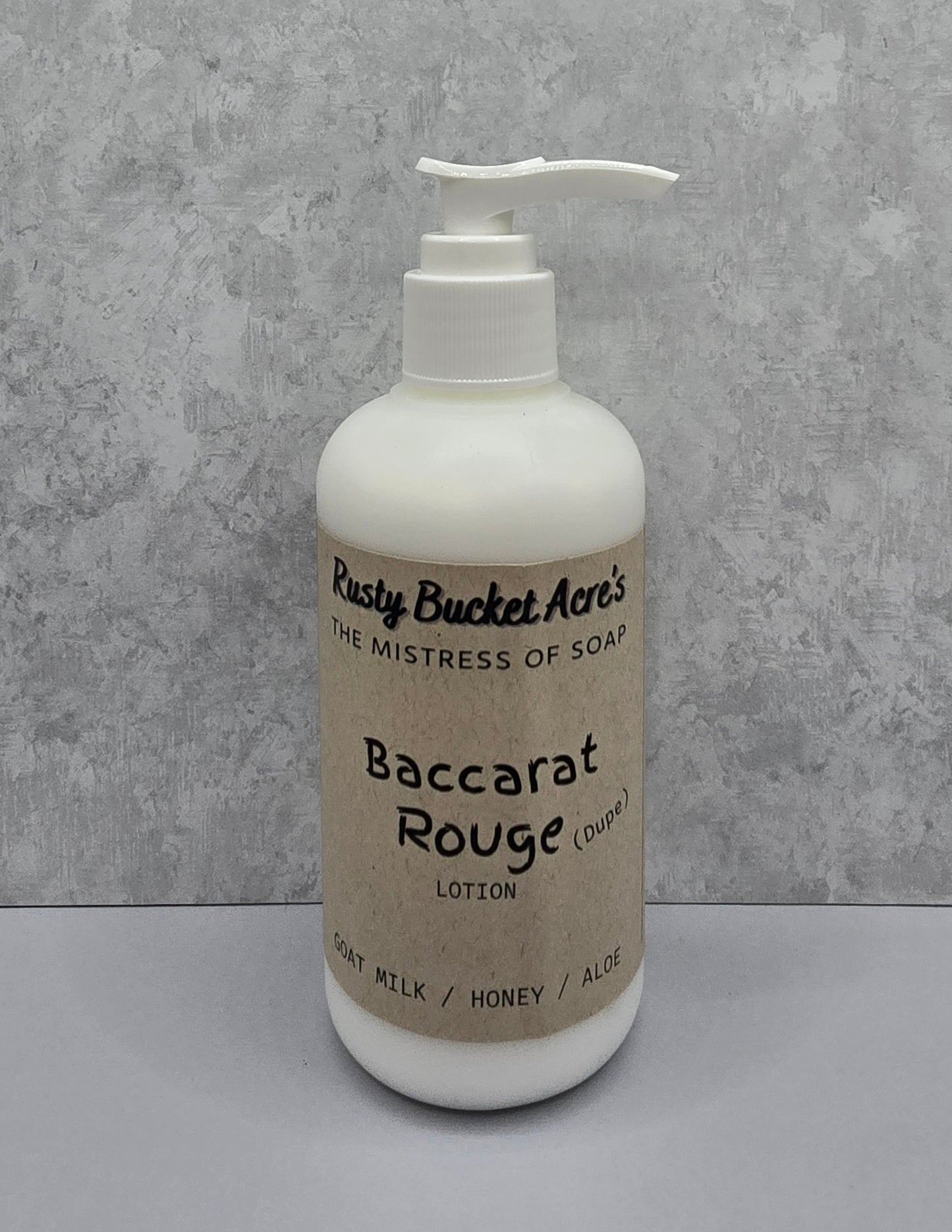 Lotion bottle with 'Rusty Bucket Acres Baccarat Rouge Dupe' label on a gray background