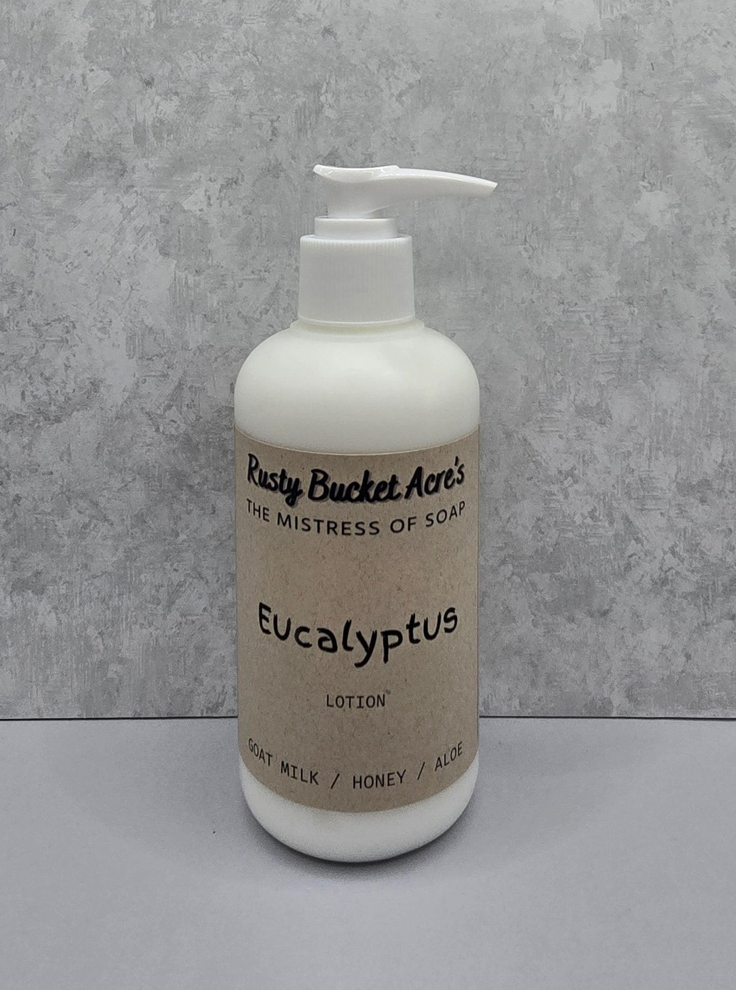 Lotion bottle with 'Rusty Bucket Acres Eucalyptus' label on a gray background